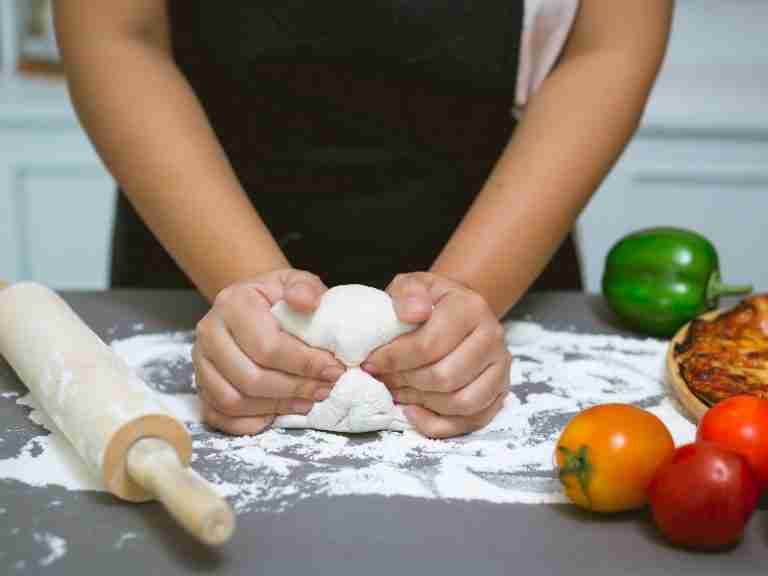 woman kneading a dough for pizza