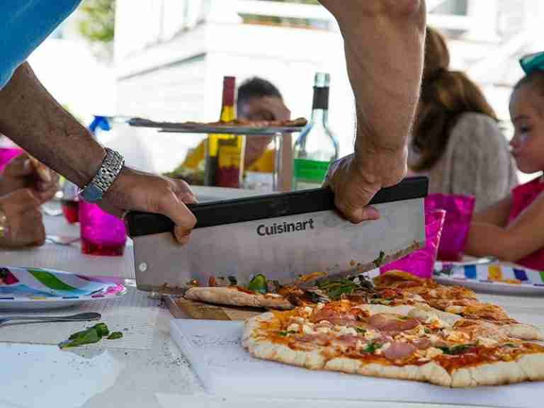 person cuttimg a pizza